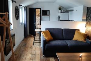 a living room with a couch and a kitchen at Studio chaleureux en hyper centre in Charleville-Mézières