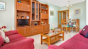 ein Wohnzimmer mit zwei roten Sofas und einem Tisch in der Unterkunft 2 Ross - Lloret de Mar in Lloret de Mar
