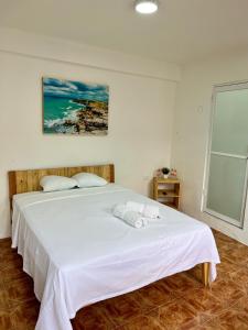 een slaapkamer met een groot wit bed en handdoeken bij Hotel Masam Isla Mujeres in Isla Mujeres