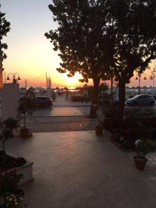 a sunset in a parking lot with trees and cars at Hotel Royal in Giulianova