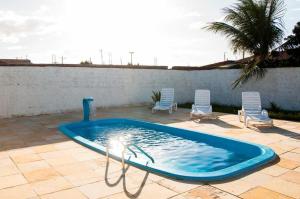 a swimming pool with two lawn chairs at Hotel Ouro Negro in Guamaré