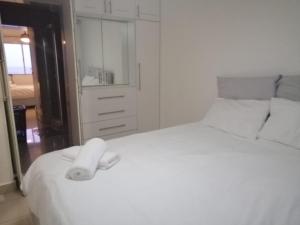 um quarto com uma cama branca com uma toalha em Beachfront - 34 Blue Largo em Westbrook