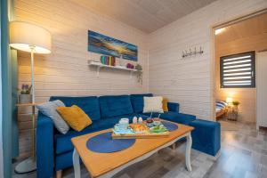 a living room with a blue couch and a table at Domki letniskowe Alma, Jarosławiec in Jarosławiec