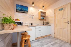 a kitchen with white cabinets and a wooden door at Domki letniskowe Alma, Jarosławiec in Jarosławiec