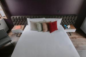 a bedroom with a large white bed with pillows at Matiana Estudiante in Zacatecas