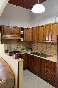 a kitchen with wooden cabinets and a sink at A casa di Ida in Fuscaldo