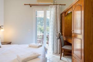 a bedroom with a bed and a chair and a window at Sea Breeze Hotel & Apartments in Agios Gordios