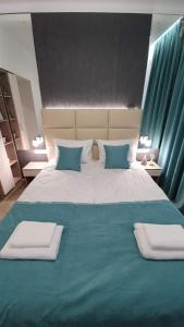 uma cama grande com lençóis e almofadas azuis e brancos em DeMar Apart Tiffani em Lviv
