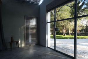 - une porte ouverte dans une pièce dotée de grandes fenêtres dans l'établissement Alloggio nei Trulli della Masseria Collina Casanoja, à Noci