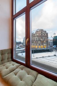 a window with a couch looking out at a building at Romari площа Міцкевича in Lviv