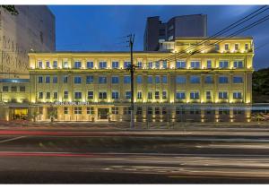 a large yellow building on a city street at night at Hotel Global Grupos in Sao Paulo