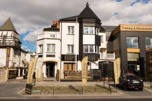 a large white building with a sign in front of it at Lezzet PG B&B &TurkishRestaurant in Warsaw