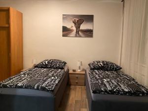 a room with two beds and a picture of an elephant at Černý Tulipán - Apartmán 2 in Pilsen