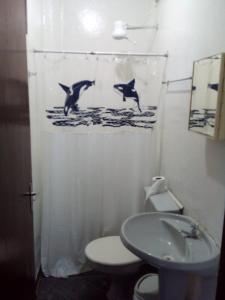 a bathroom with a shower curtain with dolphins in the water at Excellence Apart in Ubatuba