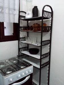 a shelf with dishes and a stove in a kitchen at Excellence Apart in Ubatuba