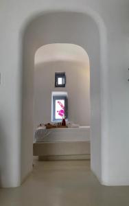 a white room with a bed and a window at Palmariva Villas in Fira