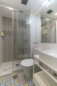 ein Bad mit einer Dusche, einem WC und einem Waschbecken in der Unterkunft Portucale Guest House- Self check-in in Porto
