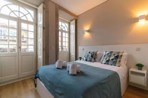 a bedroom with a large bed with a blue blanket at Portucale Guest House- Self check-in in Porto