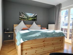 a bedroom with a wooden bed with a wooden headboard at Hotel Garni Forsthaus Ruhpolding incl Chiemgau Karte in Ruhpolding