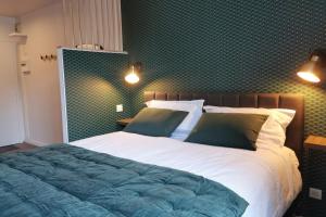 a bedroom with a large bed with green wallpaper at Appart de charme Hyper-centre LIMOGES ! in Limoges