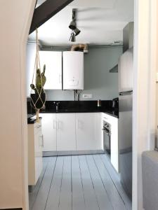 a kitchen with white cabinets and a white floor at Coup de coeur 42 m2 ! Hyper centre LIMOGES GARE in Limoges