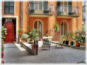a courtyard with a table and chairs in front of a building at Casa Vacanze Touring in Verbania