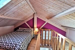 - une chambre mansardée avec un lit et des murs violets dans l'établissement Splendide Maison 5 chambres ! Quartier Historique, à Limoges