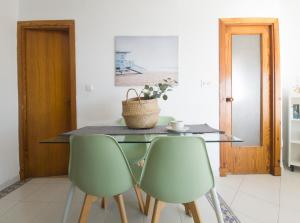 アルムニェーカルにあるIncreíble apartamento al marのダイニングルーム(緑の椅子2脚、テーブル付)