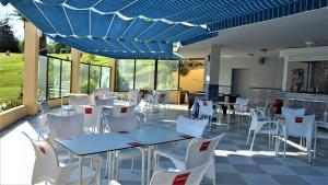 restauracja z białymi krzesłami i stołami oraz niebieskim sufitem w obiekcie Apartamento Estudio Ruymar Jupiter w mieście Benalmádena