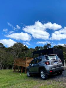 a small car parked next to a wooden bench at Tinyhouse da Floresta in Urubici
