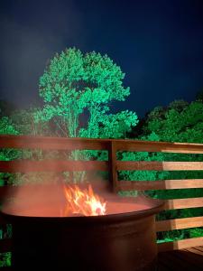 a fire pit in front of a fence with a tree at Tinyhouse da Floresta in Urubici