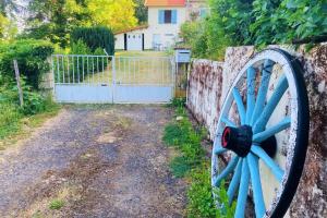 une roue bleue du wagon devant une porte dans l'établissement La Belle Vue - Coin de paradis, à Sussac