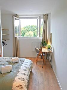 1 dormitorio con cama, escritorio y ventana en Lovely T2 - Proche du CHU LIMOGES, en Isle