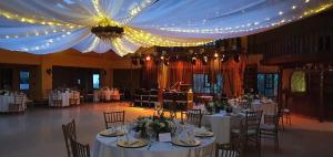 - une salle de banquet avec des tables blanches, des chaises et des lumières dans l'établissement Hacienda Buenos Aires en Iza, à Iza