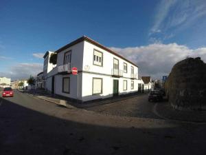 un bâtiment blanc sur le côté d'une rue dans l'établissement Costa Norte Guesthouse, à Ribeira Grande