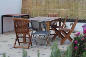 een houten tafel en vier stoelen rond een tafel bij Costa Norte Guesthouse in Ribeira Grande