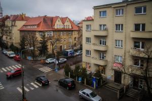 vistas a una calle de la ciudad con coches aparcados en Apartament Moniuszki 22 en Toruń