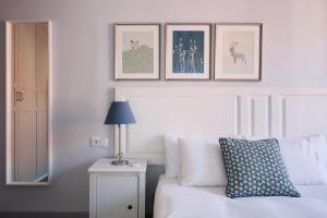 バルセロナにあるCasa Cosi - El Farro 2の白いベッド1台、壁に3枚の絵が飾られたベッドルーム1室