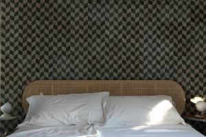 a bed with a white pillow in front of a wall at Alloggio nei Trulli della Masseria Collina Casanoja in Noci