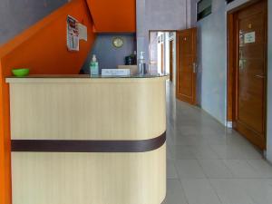 een bar in een restaurant met een oranje muur bij Wisma Tulus Syariah Kebumen Mitra RedDoorz in Kebumen