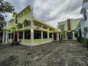 un edificio con una motocicleta estacionada frente a él en Wisma Tulus Syariah Kebumen Mitra RedDoorz, en Kebumen