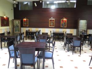 uma sala de jantar com paredes e mesas e cadeiras de madeira em Hotel Don Miguel Plaza em Berja