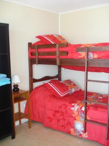 a bedroom with two bunk beds and a red bed at La Serena Sol y Mar in La Serena +24 photos