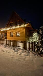 una cabaña de madera con luces de Navidad en ella en Drevenička Anička - Liptovská Mara, en Liptovský Trnovec
