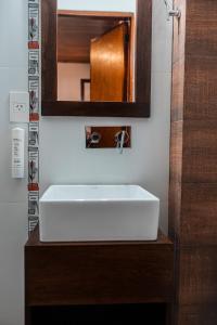 een badkamer met een witte wastafel en een spiegel bij Hotel Cuatro Pinos in Oberá