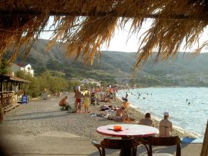 a group of people on a beach near the water at Apartments Galeb Pag - Beach in Pag