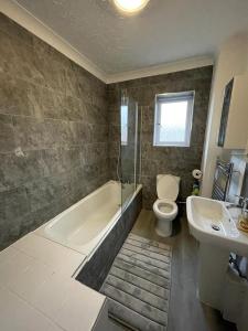 een badkamer met een bad, een toilet en een wastafel bij Alder En-Suites Self-Catering with private shower 1 in Southampton