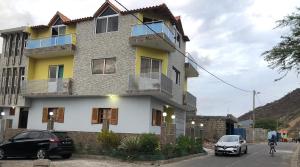 un edificio con due auto parcheggiate di fronte di Dunas De Areia Preta a Ribeira da Prata