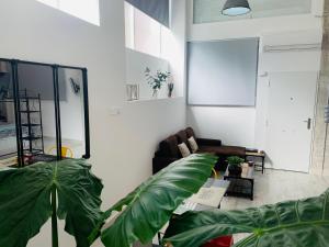 salon z kanapą i 2 dużymi roślinami w obiekcie Coco Homes w Madrycie
