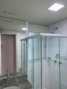 um banheiro com box de vidro e pia em TEMPORADA737 TOP 03 QUARTOS na ATALAIA em Aracaju